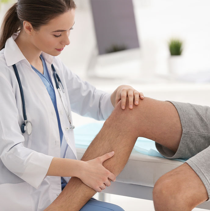 Doctor examining patients knee joint to see if they qualify for Advanced Joint Pain Relief