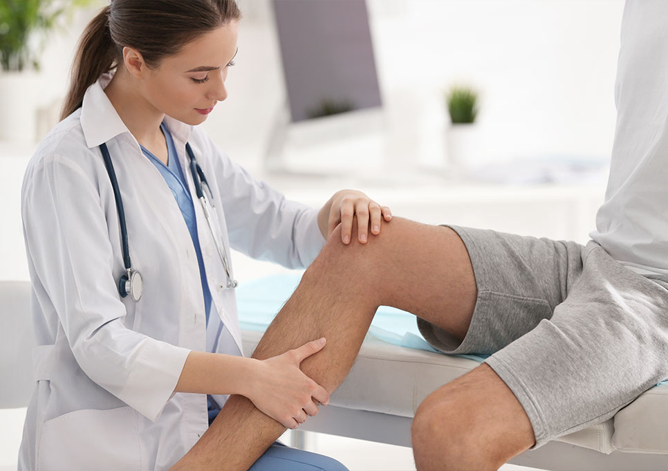 Doctor examining patients knee joint for cause of pain